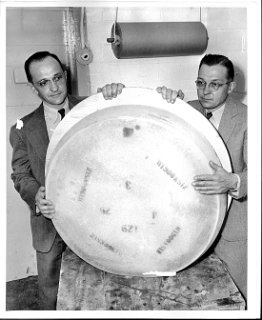 Fritz (left) and Art Escher with a wheel of Swiss cheese.